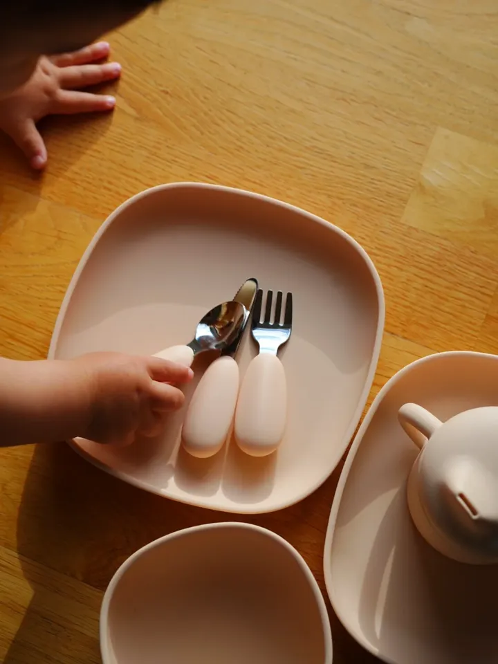 Parent holding toddler with cup